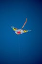 Vertical shot of a colorful kite flying in the air in blue sky background Royalty Free Stock Photo