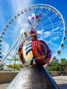 Vertical shot of a colorful statue against a Ferris Wheel at the Albert docks attraction Liverpool