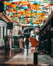 Vertical shot of colorful umbrellas over a pedestrian alley in Old Town Bucharest