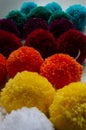 Vertical shot of colorful wool pom poms for fabric decoration Royalty Free Stock Photo