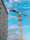 Vertical shot of a construction crane near a building Royalty Free Stock Photo