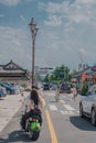 Vertical shot of a couple driving on a motorcycle and cars parked in Seoul, South Korea