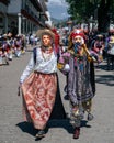 Vertical shot of a couple in traditional Mexican masks walking on the streets during a festival