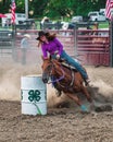 Vertical shot of a cowgirl barrel racing at the Wyandotte County Kansas Fair Rodeo