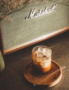 Vertical shot of a cup of cold brew latte coffee in a cafe on a wooden plate