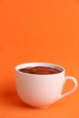 Vertical shot of a cup of hot chocolate isolated on an orange background Royalty Free Stock Photo
