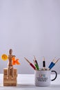 Vertical shot cup of pencils and wooden mannequin. Royalty Free Stock Photo