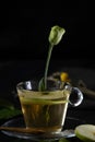 Vertical shot of a cup of spiced tea with a beautiful rose bud and a slice of apple Royalty Free Stock Photo