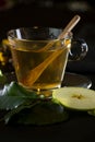 Vertical shot of a cup of spiced tea with a wooden spoon and an apple slice Royalty Free Stock Photo