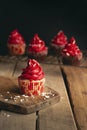 Vertical shot of a cupcake with red cream on a wooden surface Royalty Free Stock Photo