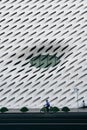 Vertical shot of a cyclist riding against The Broad modern art museum, Los Angeles, CA, USA