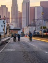 Vertical shot of cyclists riding on an empty street towards of kyscrapers of Los Angeles at sunset