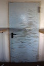 Vertical shot of a damaged metal door from inside a home Royalty Free Stock Photo