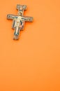 Vertical shot of a decorated cross isolated on an orange background