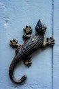 Vertical shot of decorative metallic lizard on the wall Royalty Free Stock Photo