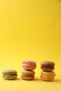 Vertical shot of delicious assorted macaroons on a yellow background