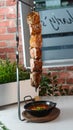 Vertical shot of delicious barbeque hanging over a bowl of soup