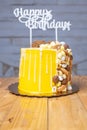 Vertical shot of a delicious birthday cake decorated with chocolate pieces on a wooden table