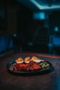 Vertical shot of delicious grilled meat, grilled potatoes with cheese, and basil on the plate Royalty Free Stock Photo