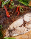 Vertical shot of delicious seasoned fish on a wooden plate