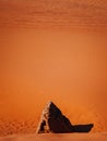 Vertical shot of a desert with golden sand ripples and a large rock - background, wallpaper Royalty Free Stock Photo