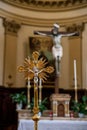 Vertical shot of detail of a golden crucifix with Jesus behind placed at the altar of a church