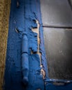 Vertical shot of the details of a wooden door with peeled off blue paint Royalty Free Stock Photo