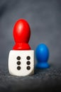 Vertical shot of dice with red and blue wooden figures around it