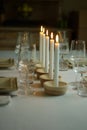 Vertical shot of a dinner table with wine glasses and candles with a blurred background