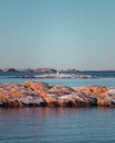 Vertical shot of a distant lighthouse a rocky sea.