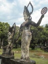 Vertical shot of a divinity sculpture in Xieng Khuan Buddha Park Laos surrounded by vegetation