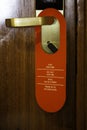 Vertical shot of the Do Not Disturb sign hanging on the hotel room door handle Royalty Free Stock Photo