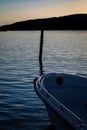 Vertical shot of a docked boat with silhouette view of a cliff in the background at sunset Royalty Free Stock Photo