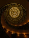 Vertical shot of a dome ceiling seen through a mysterious spiral stairway