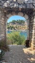 Vertical shot of a doorway of a medieval building with a river and a landscape in the background