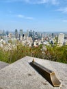 Vertical shot of downtown Montreal from the platform of Montroyal Mountain, a copper pointing arrow