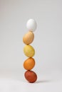 Vertical shot of Easter eggs stacked on top of one another on a white background Royalty Free Stock Photo