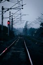 Vertical shot of an eerie railway scenery with two people walking in the distance