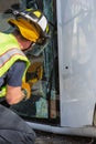 Vertical Shot of Emergency Responder Sawing Through Window on Mini Van