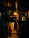 Vertical shot of an empty dark city alley at night with parked bikes