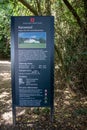 Vertical shot of an English Heritage sign about the Kenwood House with trees in the background