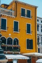 Vertical shot of the facade of a beautiful old yellow building in Venice Italy on a sunny day