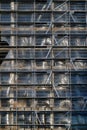 Vertical shot of the facade of a building under construction works covered with protective plastic Royalty Free Stock Photo