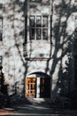 Vertical shot of a facade of an old building with tree shadows visible on it Royalty Free Stock Photo