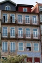 Vertical shot of facades of houses with a man looking out of a window in Porto, Portugal