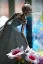 Vertical shot of a fairy figurine next to flowers