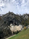 Vertical shot of the famous Predjama Castle in Slovenia under a cloudy sky