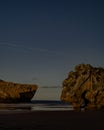 Vertical shot of a fantastic starry night sky over rock formations in a calm peaceful sea Royalty Free Stock Photo