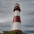 Vertical shot of a Faro De La Memoria Mar lighthouse with cloudy sky in the background in Argentina