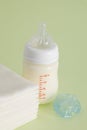 Vertical shot of a feeding bottle with baby food, pacifier and disposable towels Royalty Free Stock Photo